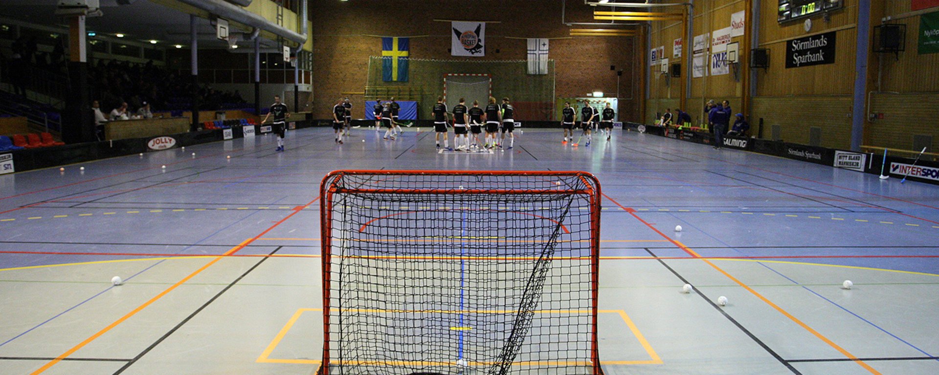 Ett innebandylag är samlat i en sporthall.